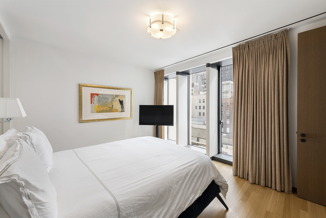 551 West 21st Street, Unit 4D Manhattan, NY 10011 - Photo 8 of 16 a bedroom with a bed and a painting on the wall
