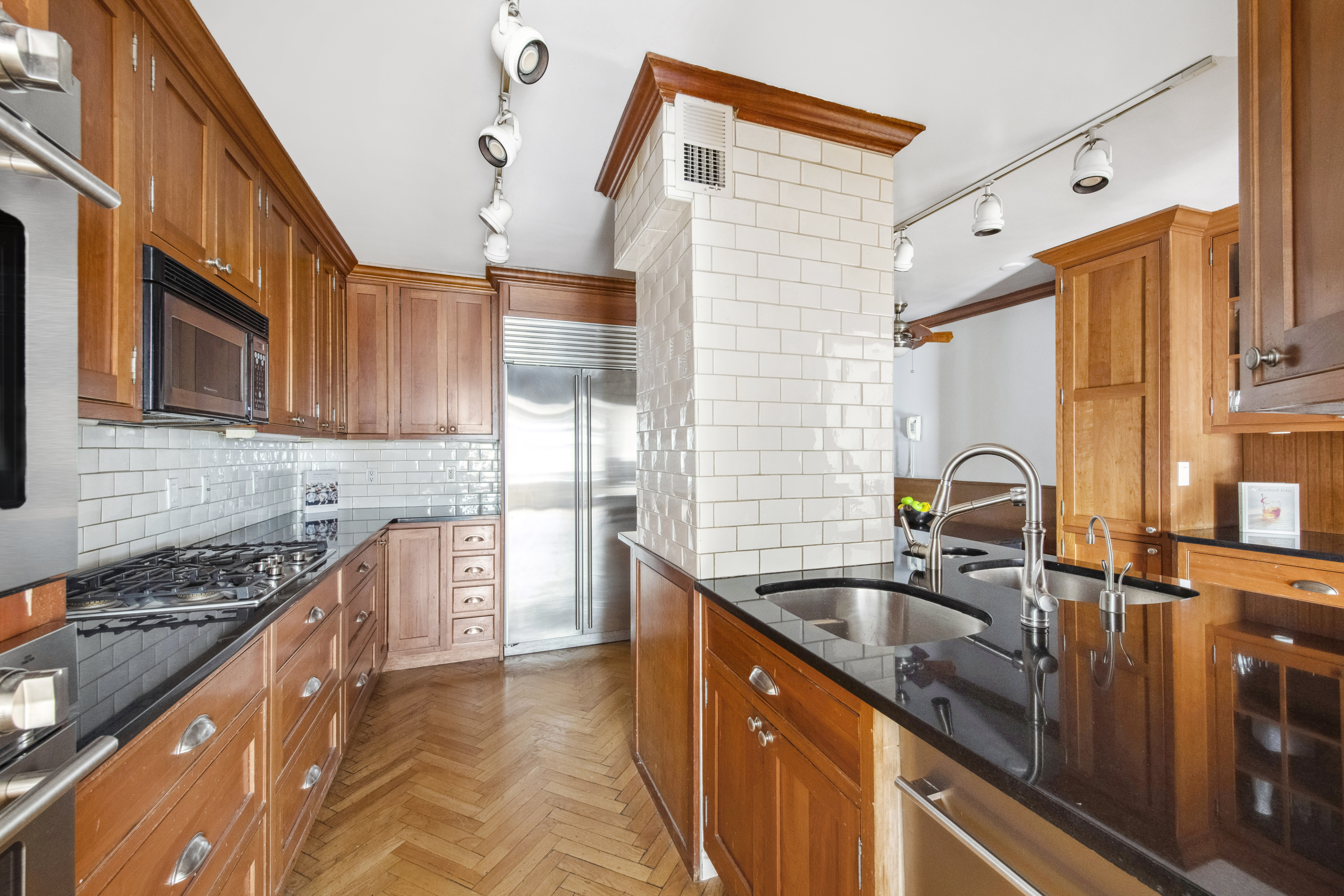 155 West 68th Street, Unit 404 Manhattan, NY 10023 - Photo 8 of 21 a kitchen with granite countertop a sink stove and cabinets