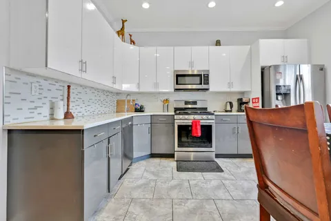 a kitchen with stainless steel appliances granite countertop a stove top oven a sink dishwasher and a refrigerator with the cabinets