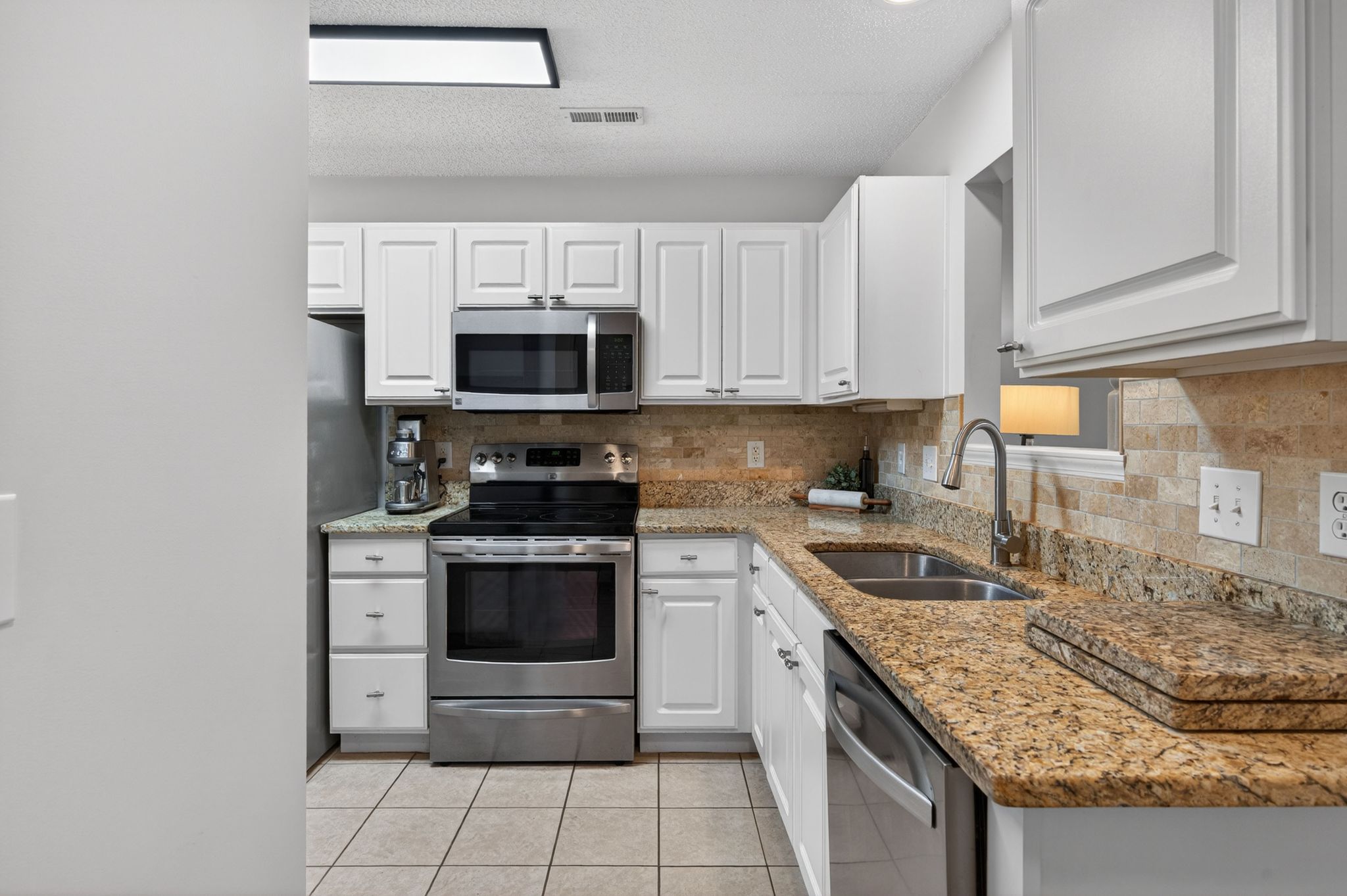 Huntscroft Lane Raleigh, NC 27617 - Photo 27 of 49 a kitchen with granite countertop a stove sink and cabinets