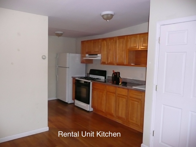 266 18th Street Brooklyn, NY 11215 - Photo 14 of 20 a kitchen with granite countertop a refrigerator a stove top oven with wooden floor