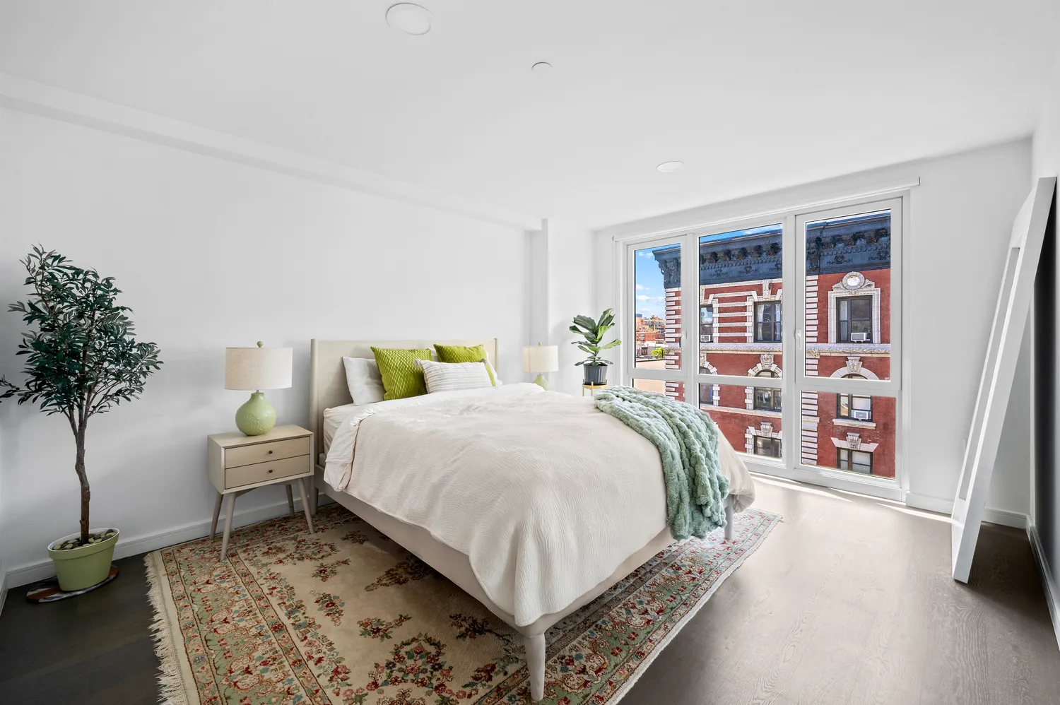 a bedroom with a large bed and a potted plant