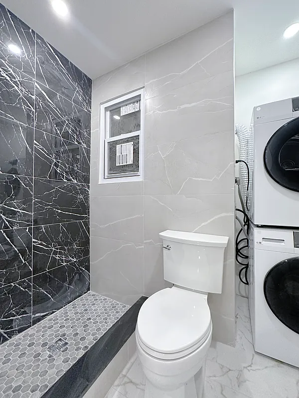 55 Spring Street, Unit 7 Manhattan, NY 10012 - Photo 10 of 12 a white toilet sitting next to a bathroom sink and a shower