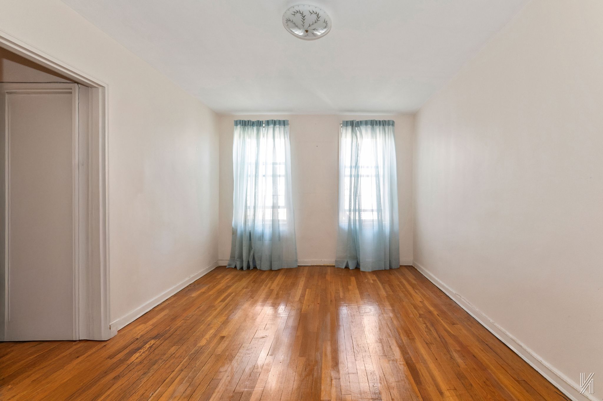 33-45 92nd Street, Unit 5G Queens, NY 11372 - Photo 5 of 8 a view of an empty room with wooden floor and a window