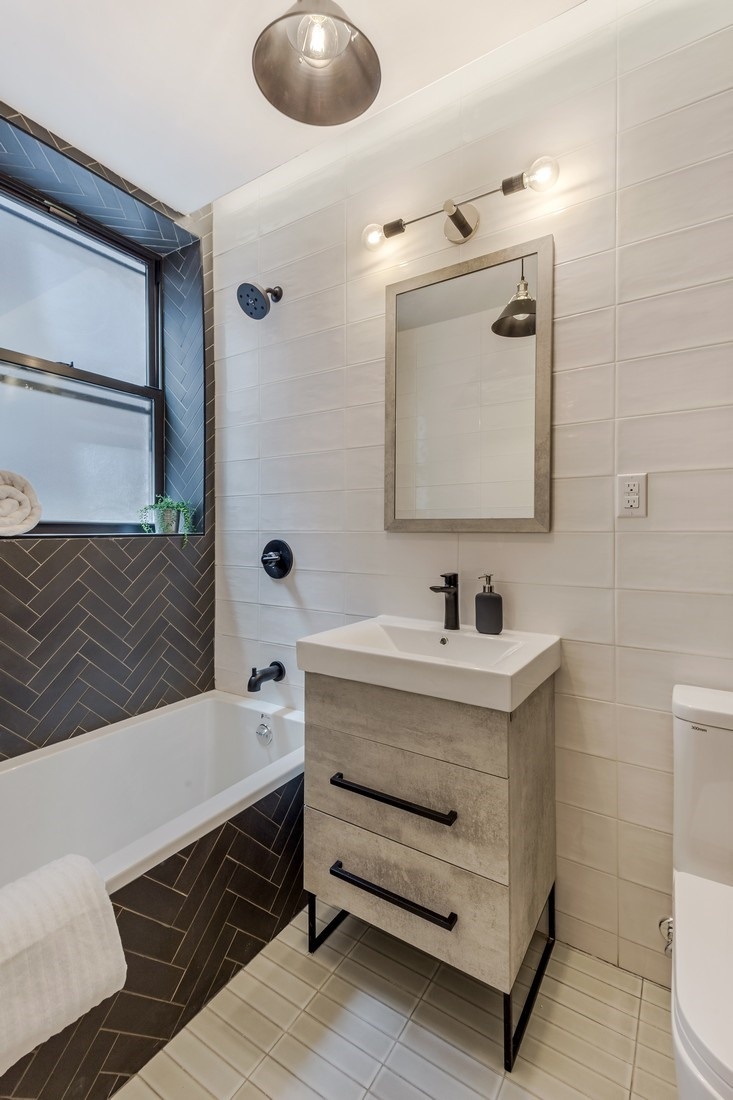 790 St Johns Place, Unit 4A Brooklyn, NY 11216 - Photo 6 of 8 a bathroom with a sink a toilet and a mirror