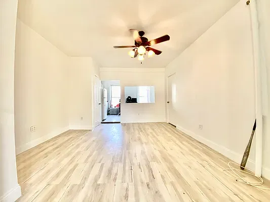 a view of a room with wooden floor and ceiling fan