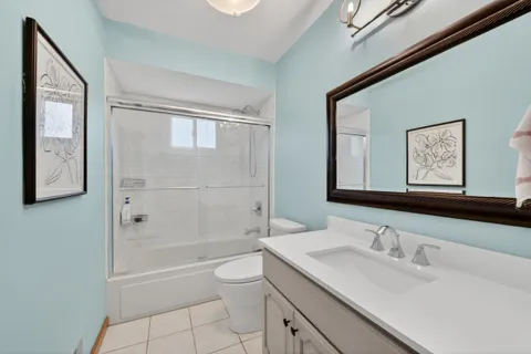 a bathroom with a granite countertop sink a toilet and shower