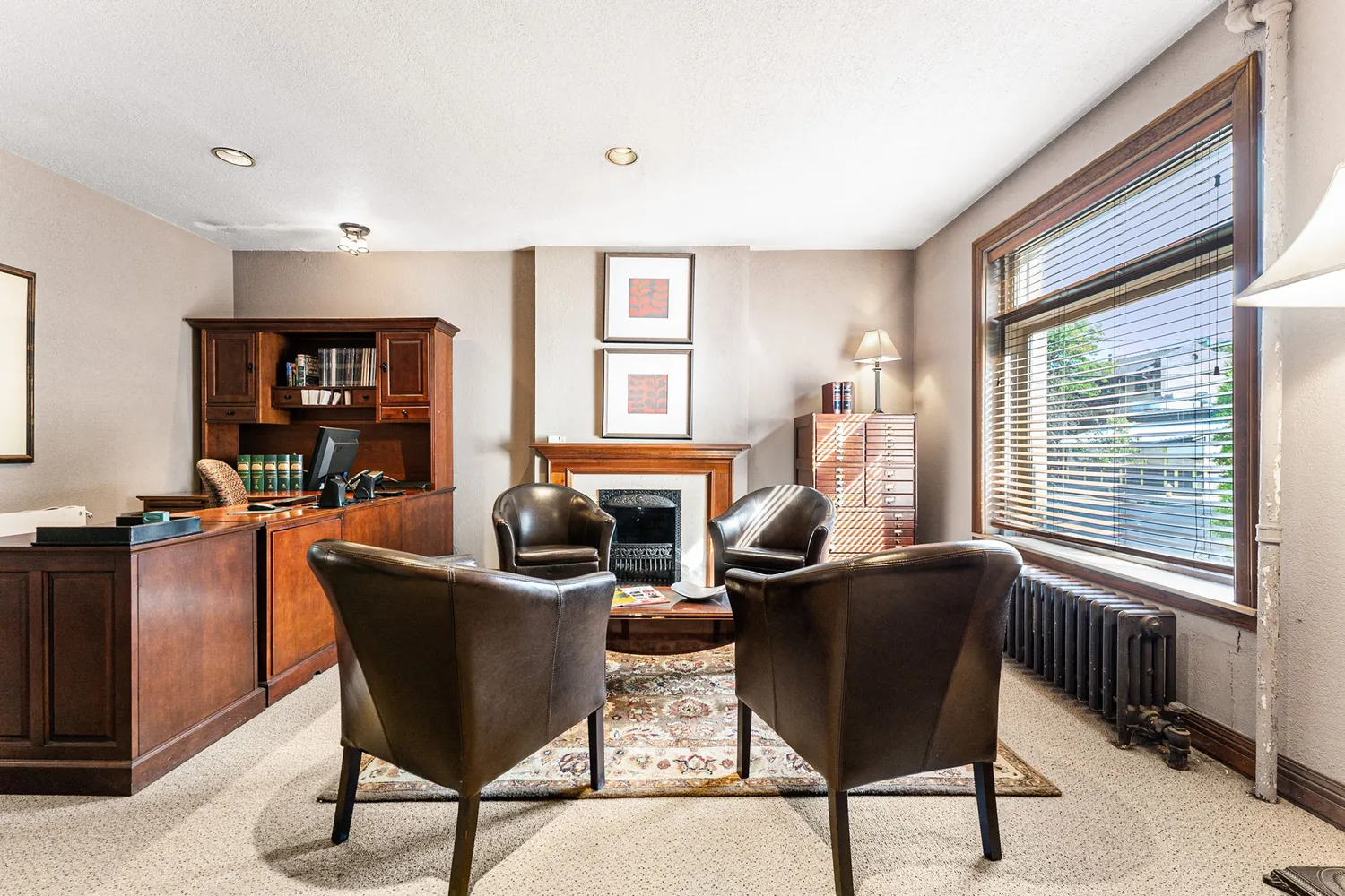 a view of a workspace with furniture and a window
