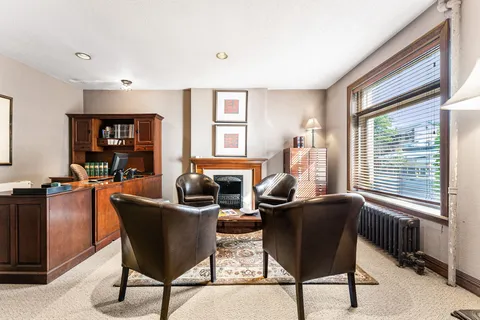 a view of a workspace with furniture and a window