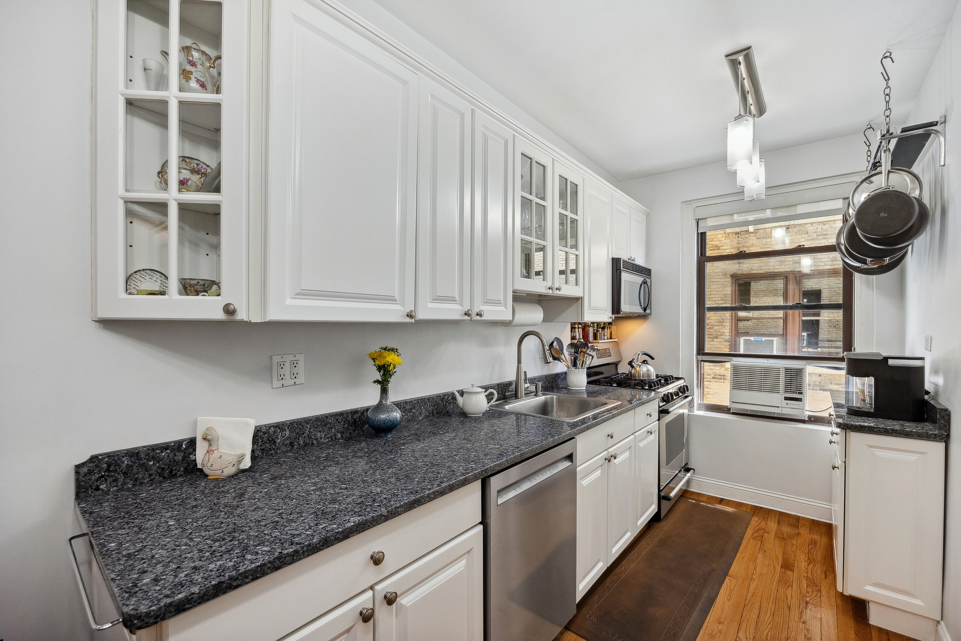 40 West 77th Street, Unit 8C Manhattan, NY 10024 - Photo 6 of 21 a kitchen with stainless steel appliances granite countertop a sink stove oven and white cabinets