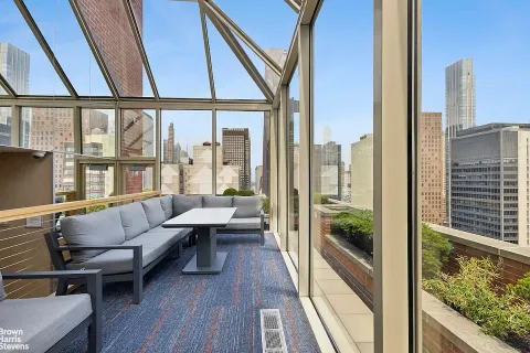 a view of roof deck with couches and city view
