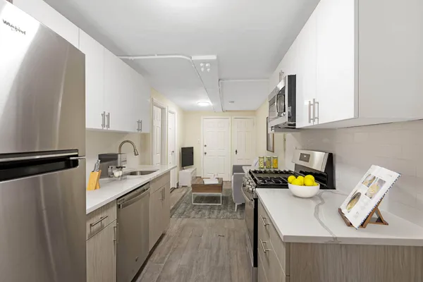 a kitchen with a refrigerator a stove a sink dishwasher and white cabinets with wooden floor