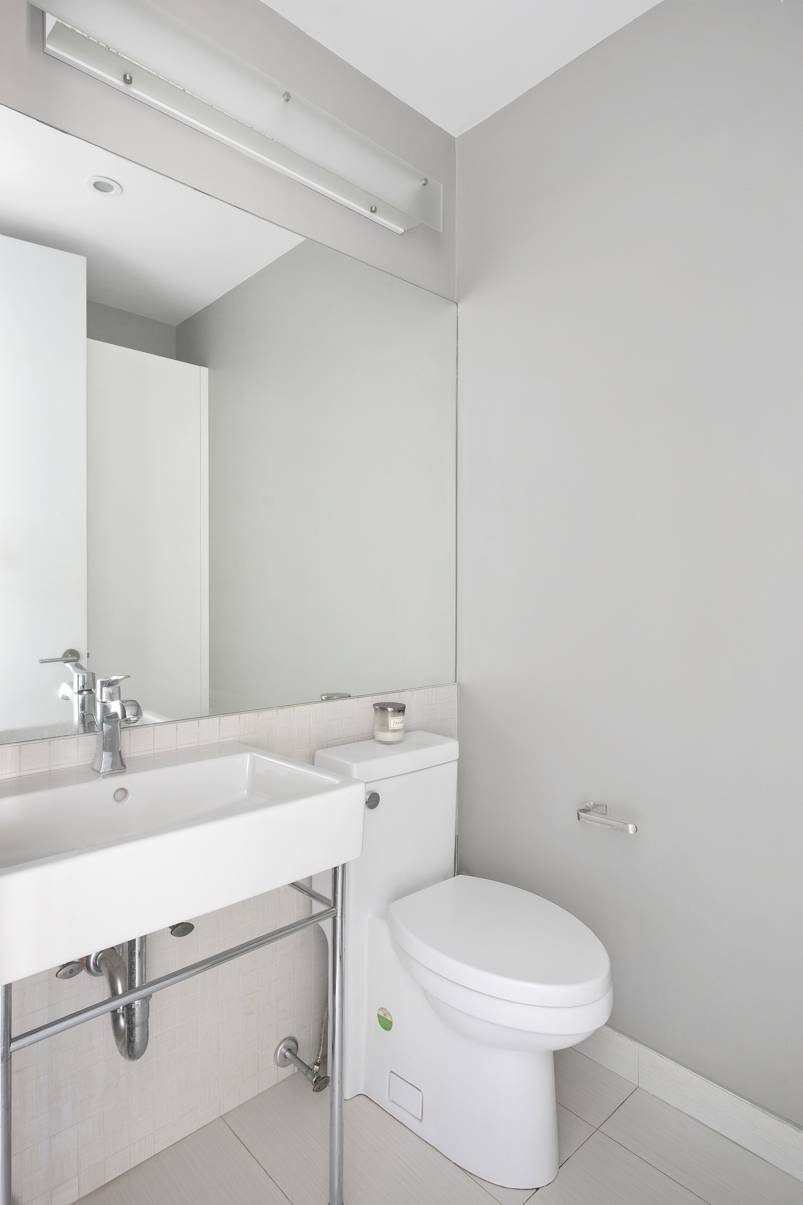 350 West 50th Street, Unit PH4B Manhattan, NY 10019 - Photo 11 of 18 a bathroom with a sink a toilet and mirror