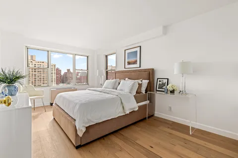 a bedroom with a bed a table and window