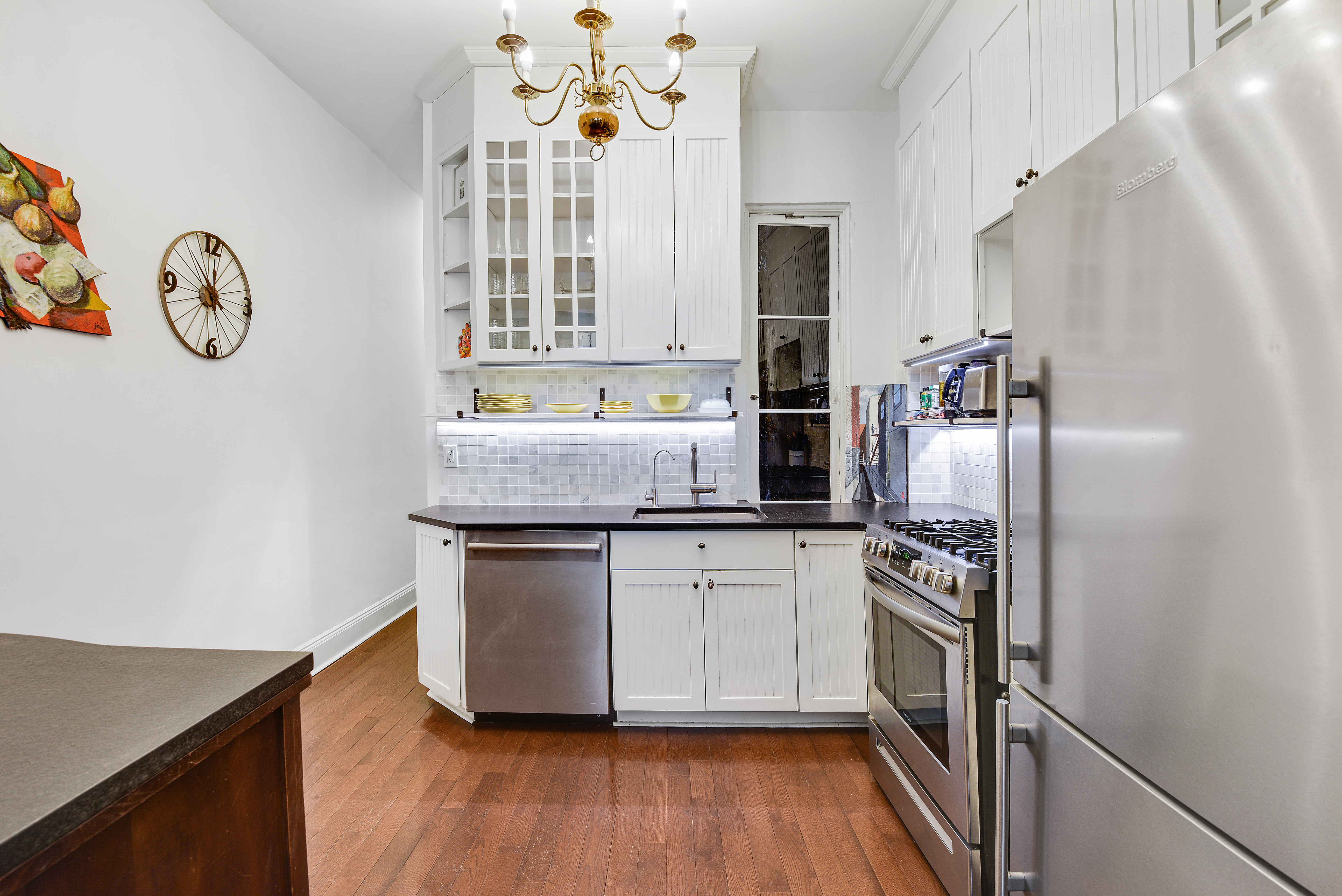 436 East 66th Street, Unit 1W Manhattan, NY 10065 - Photo 9 of 19 a kitchen with stainless steel appliances granite countertop a refrigerator a stove and a wooden floors