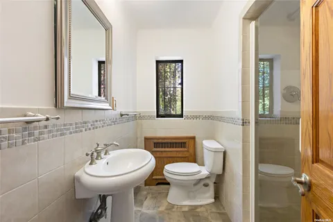 a bathroom with a toilet sink and mirror