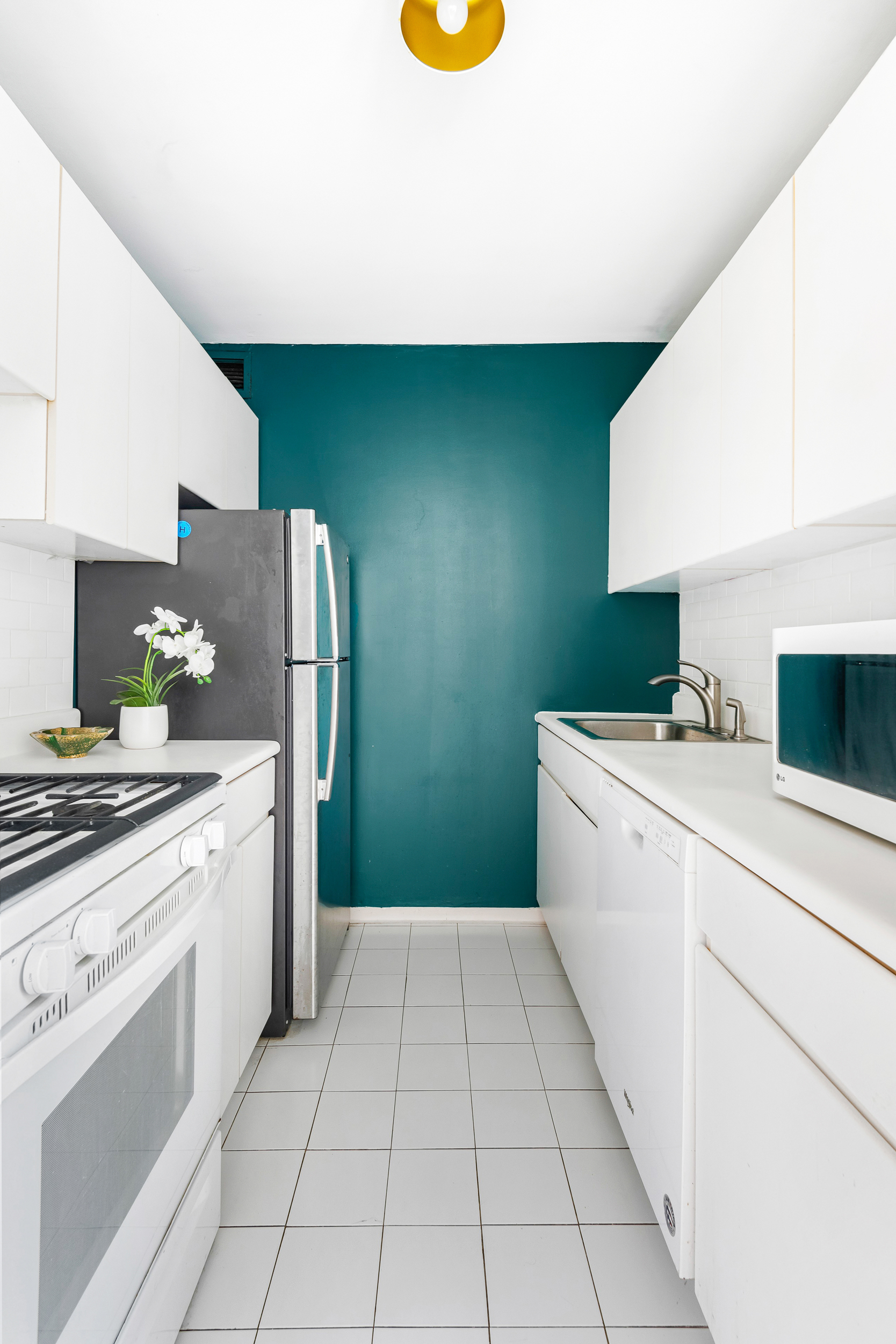 250 South End Avenue, Unit 3F Manhattan, NY 10280 - Photo 3 of 11 a kitchen with a refrigerator and a stove top oven