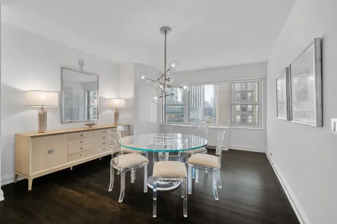 a dining room with furniture a chandelier and wooden floor