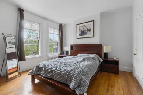 a bedroom with a bed and wooden floor