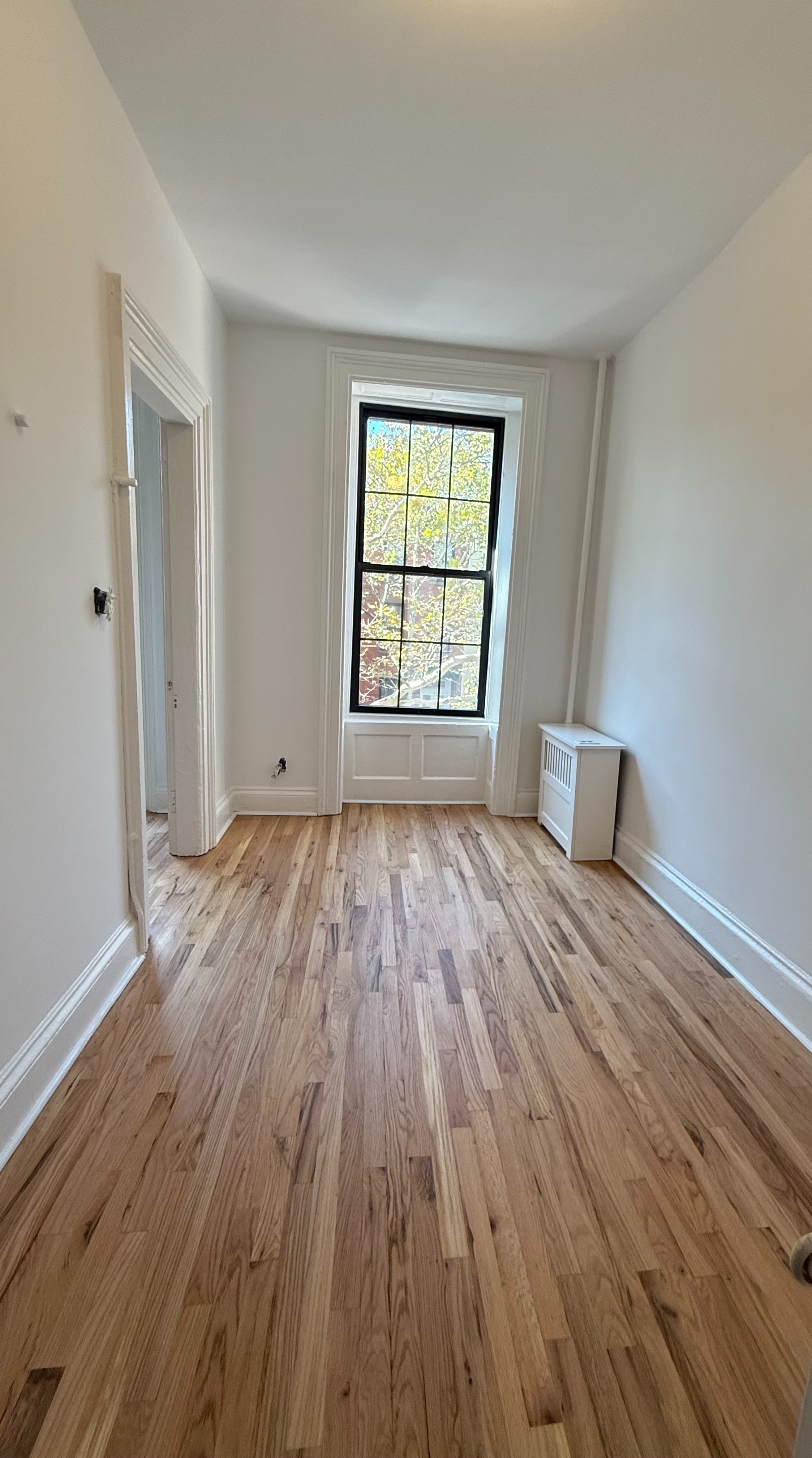 141 Summit Street, Unit 3 Brooklyn, NY 11231 - Photo 8 of 17 a view of empty room with wooden floor and fan