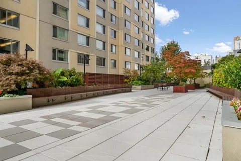 a view of a building with a bench and tables