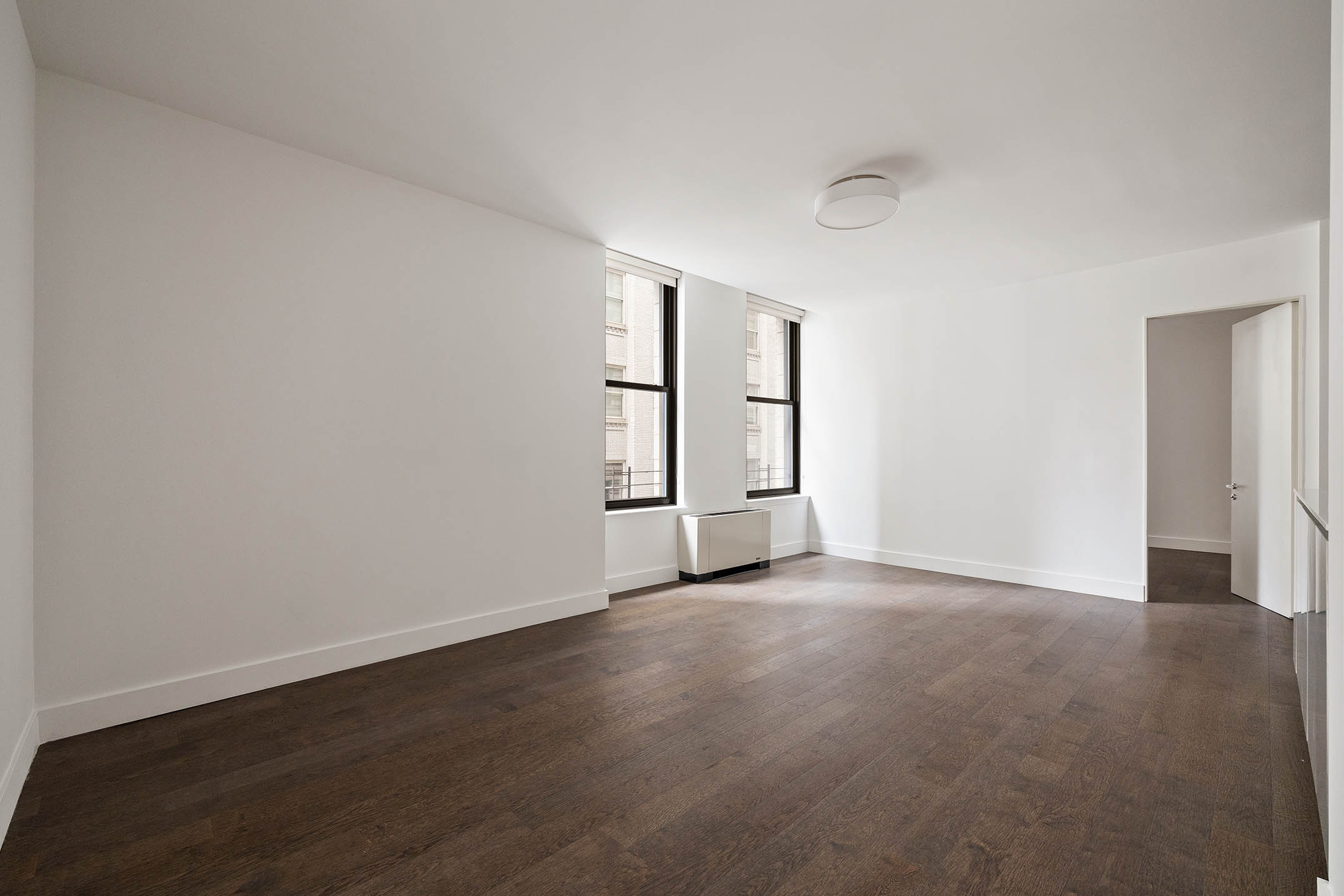 25 Broad Street, Unit 16I Manhattan, NY 10004 - Photo 4 of 23 an empty room with windows