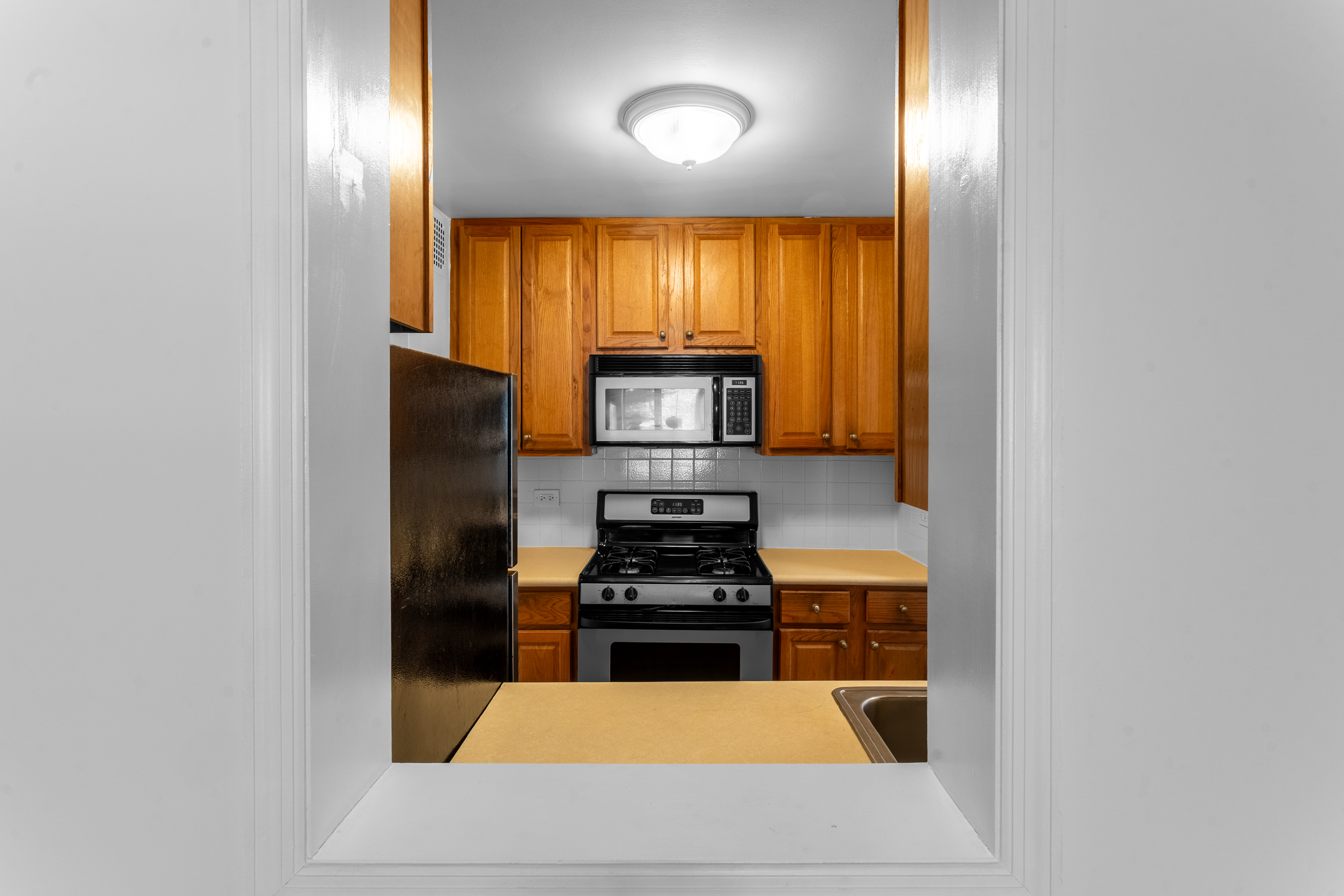 2750 Johnson Avenue, Unit 6E Bronx, NY 10463 - Photo 4 of 14 a kitchen with granite countertop white cabinets and black stainless steel appliances