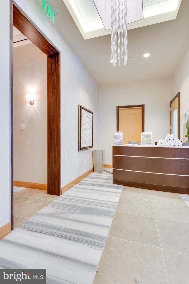 1881 North Nash Street, Unit 1009 Arlington, VA 22209 - Photo 20 of 36 a bedroom with a bed and a chandelier