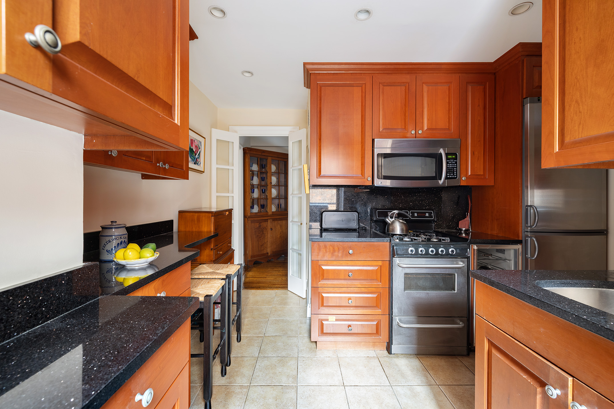 151 East 83rd Street, Unit 6D Manhattan, NY 10028 - Photo 6 of 14 a kitchen with stainless steel appliances a stove a sink and a microwave