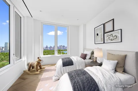 a bedroom with two beds and large window