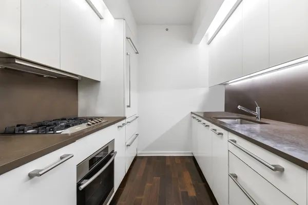 a kitchen with a stove and a wooden floor