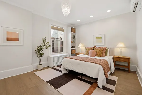 a spacious bedroom with a bed and a potted plant