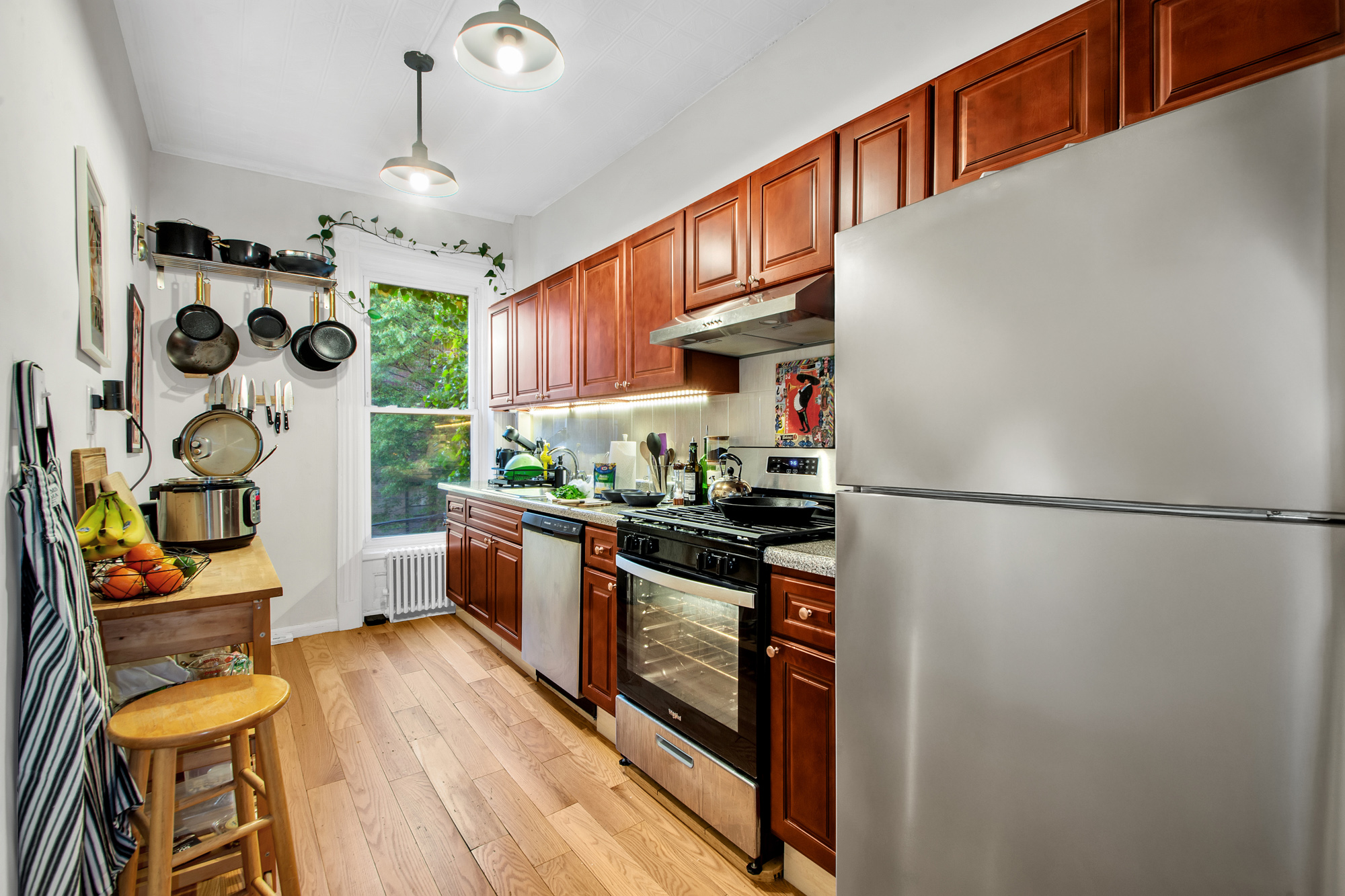 545 10th Street Brooklyn, NY 11215 - Photo 3 of 11 a kitchen with stainless steel appliances granite countertop a refrigerator a stove a sink and a dining table with wooden floor