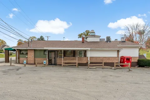 a view of a house with a patio and a yard