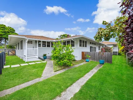 a view of a house with a big yard potted plants