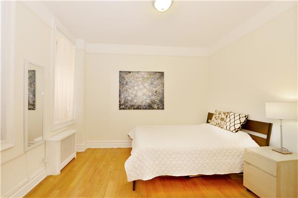 660 Riverside Drive, Unit 1B Manhattan, NY 10031 - Photo 3 of 5 a bedroom with a bed and a painting on the wall