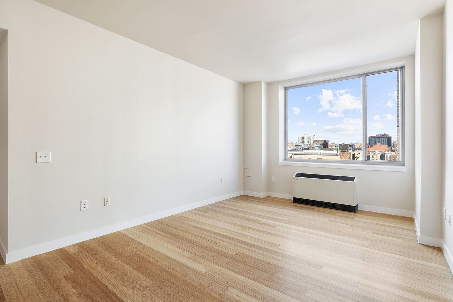 40 West 116th Street, Unit A808 Manhattan, NY 10026 - Photo 2 of 19 a view of an empty room with wooden floor and a window