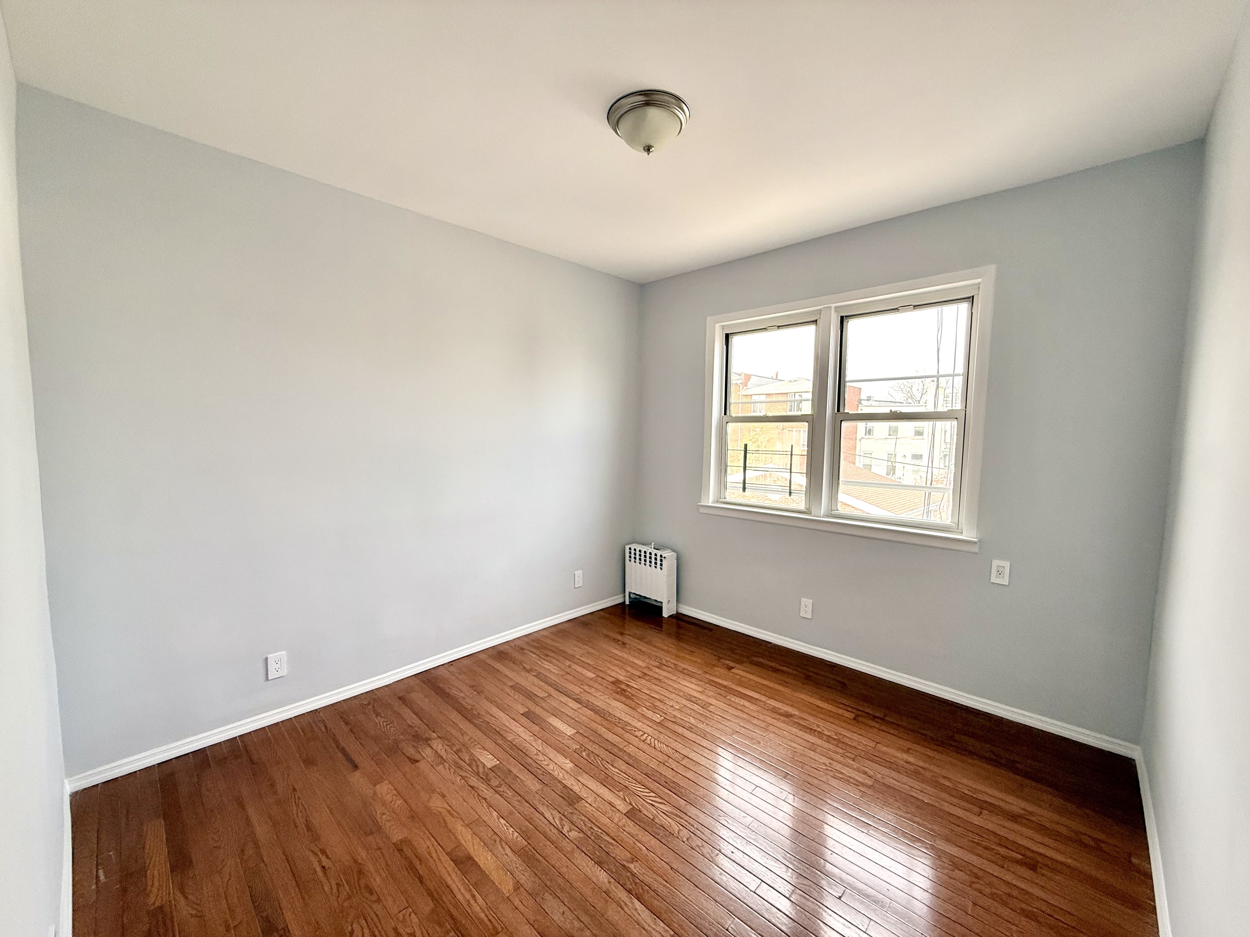 1675 85th Street, Unit 2R Brooklyn, NY 11214 - Photo 5 of 6 an empty room with windows