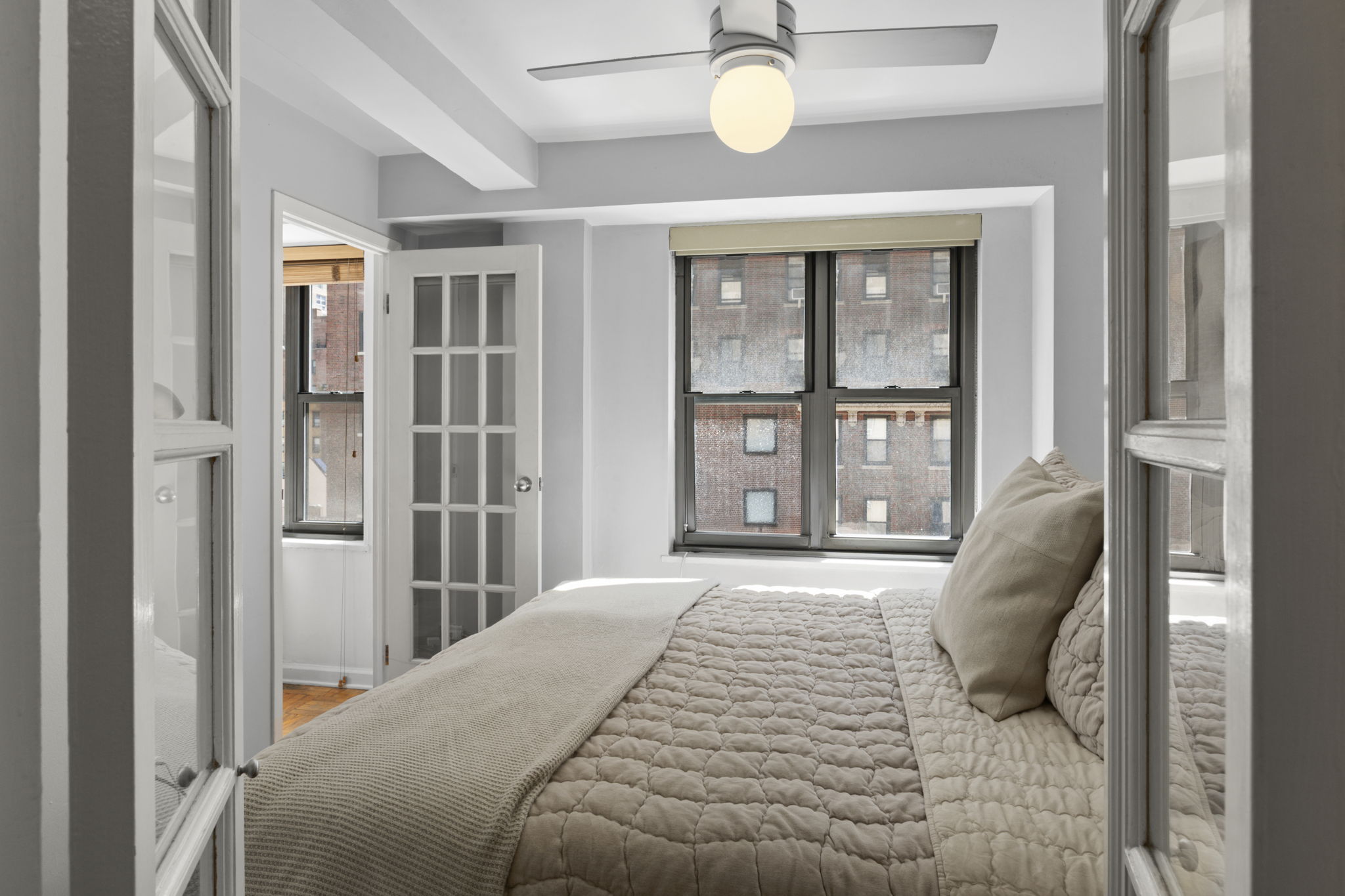 310 Lexington Avenue, Unit 9F Manhattan, NY 10016 - Photo 5 of 13 a bedroom with a bed and glass door