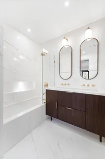 a bathroom with double vanity sinks and a mirror