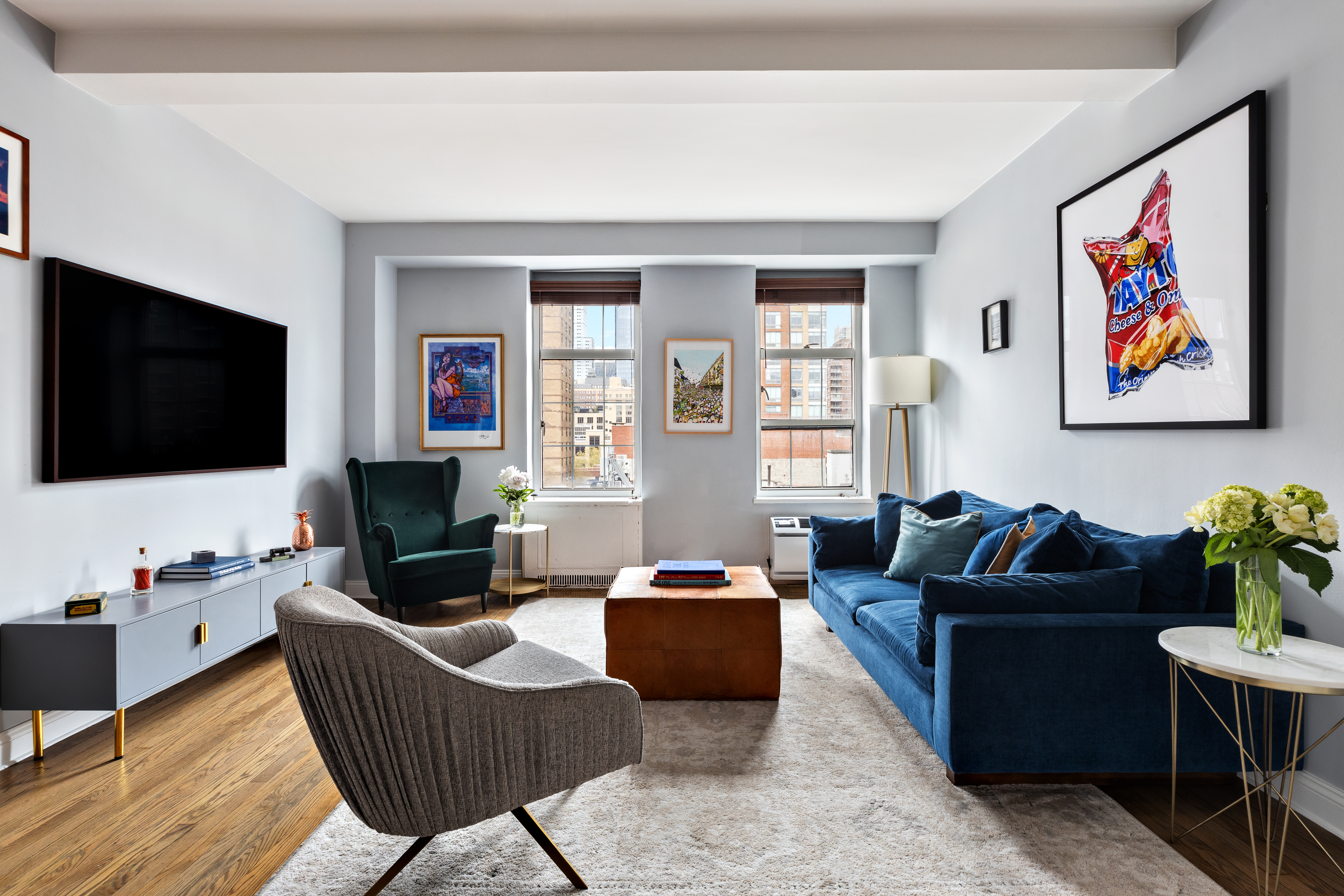410 West 24th Street, Unit 9K Manhattan, NY 10011 - Photo 2 of 10 a living room with furniture a flat screen tv and a window