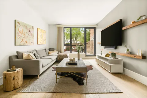 a living room with furniture a flat screen tv and a large window