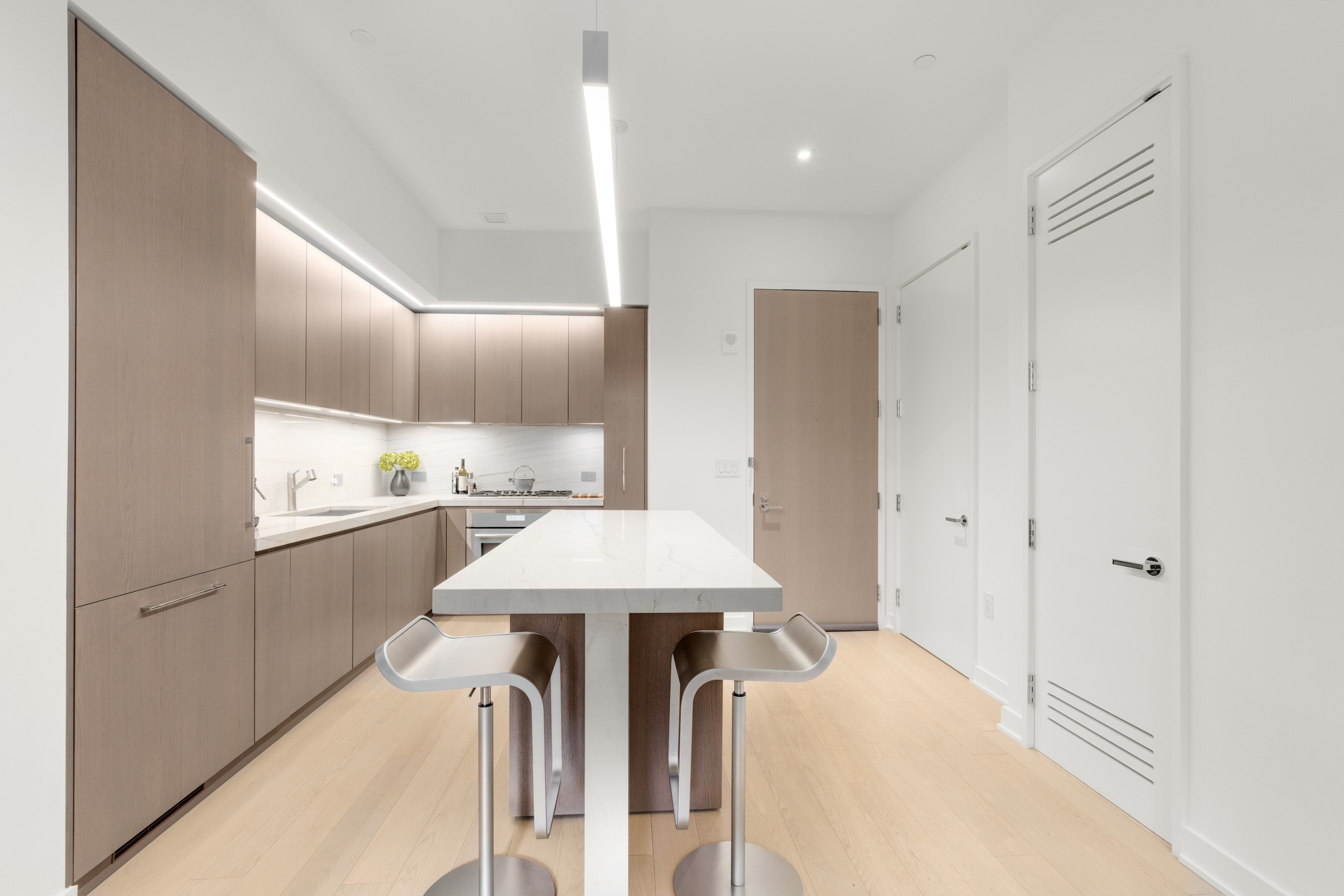 77 Charlton Street, Unit S10A Manhattan, NY 10014 - Photo 2 of 27 a kitchen with kitchen island white cabinets and refrigerator