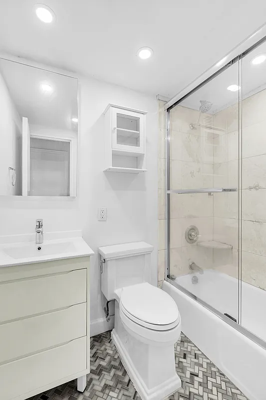 200 East 58th Street, Unit 15B Manhattan, NY 10022 - Photo 9 of 10 a bathroom with a sink toilet and shower
