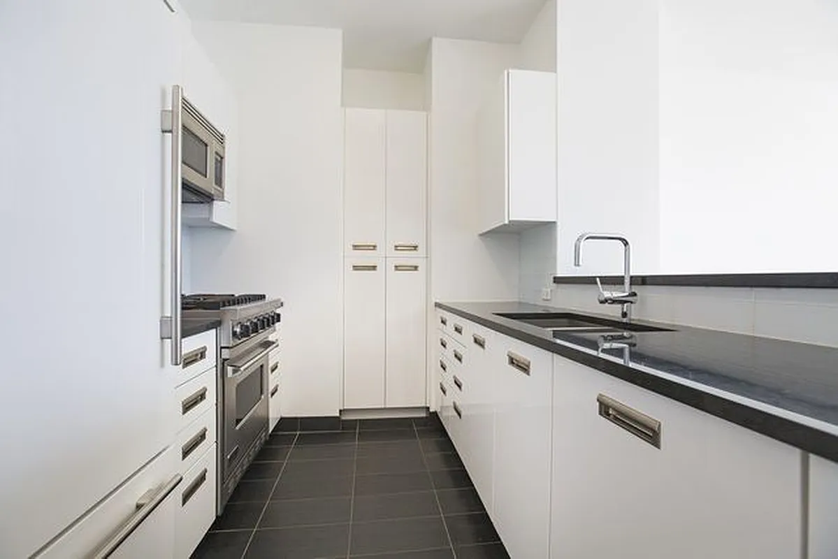 46-30 Center Boulevard, Unit 1209 Queens, NY 11109 - Photo 4 of 26 a kitchen with stainless steel appliances granite countertop a sink stove and refrigerator