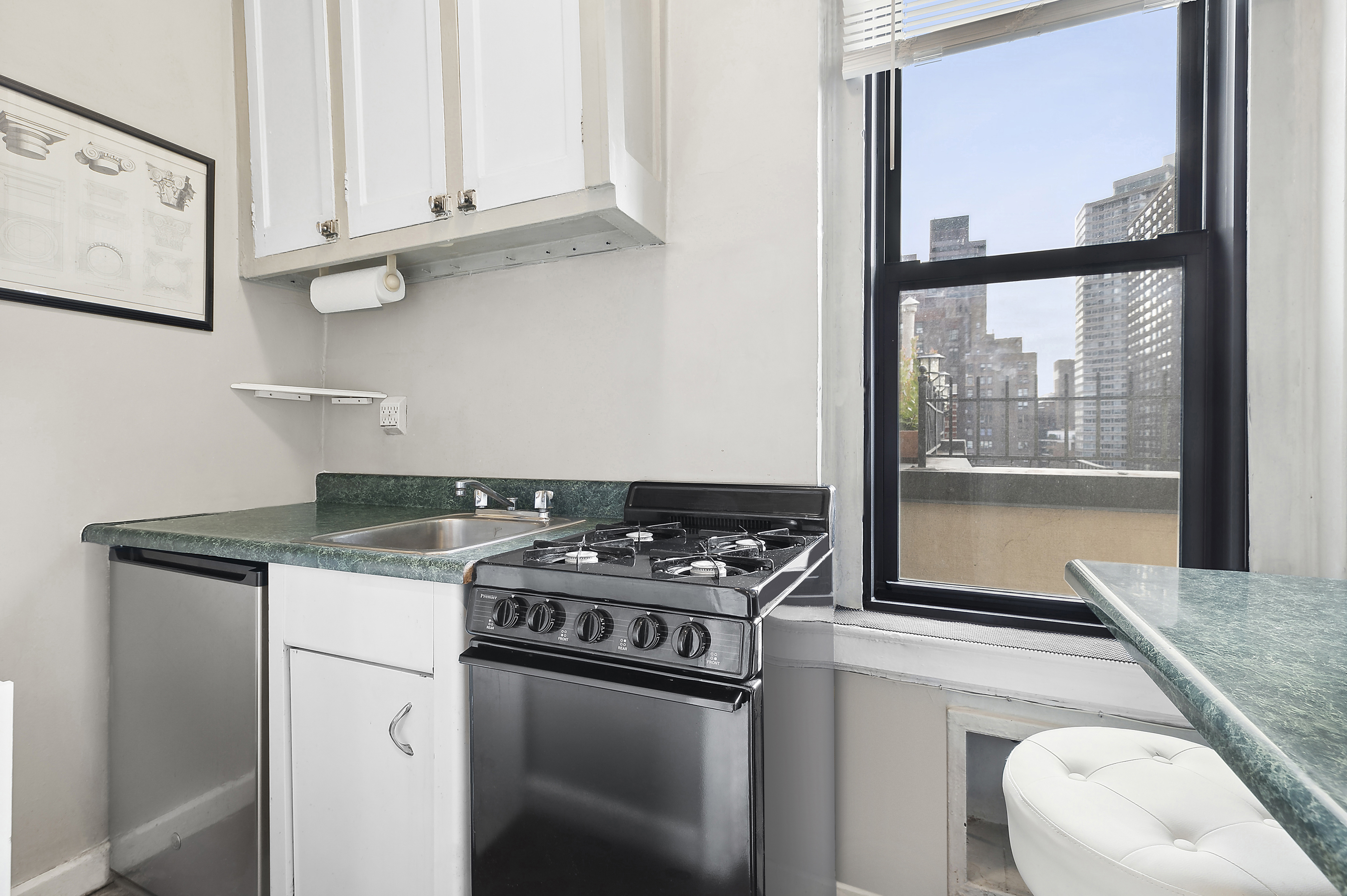 321 East 54th Street Manhattan, NY 10022 - Photo 3 of 5 a kitchen with granite countertop a stove and a sink