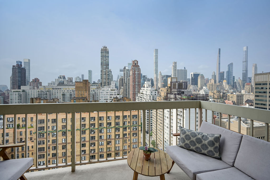 200 East 69th Street, Unit 21C Manhattan, NY 10021 - Photo 3 of 16 a view of a balcony with chairs and a potted plant