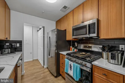 a kitchen with stainless steel appliances granite countertop a stove a refrigerator and a microwave