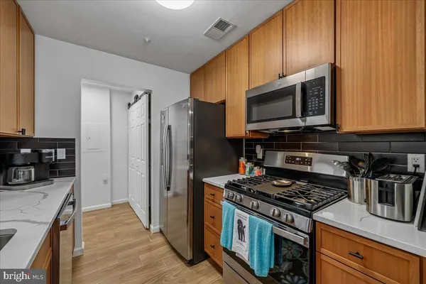 a kitchen with stainless steel appliances granite countertop a stove a refrigerator and a microwave