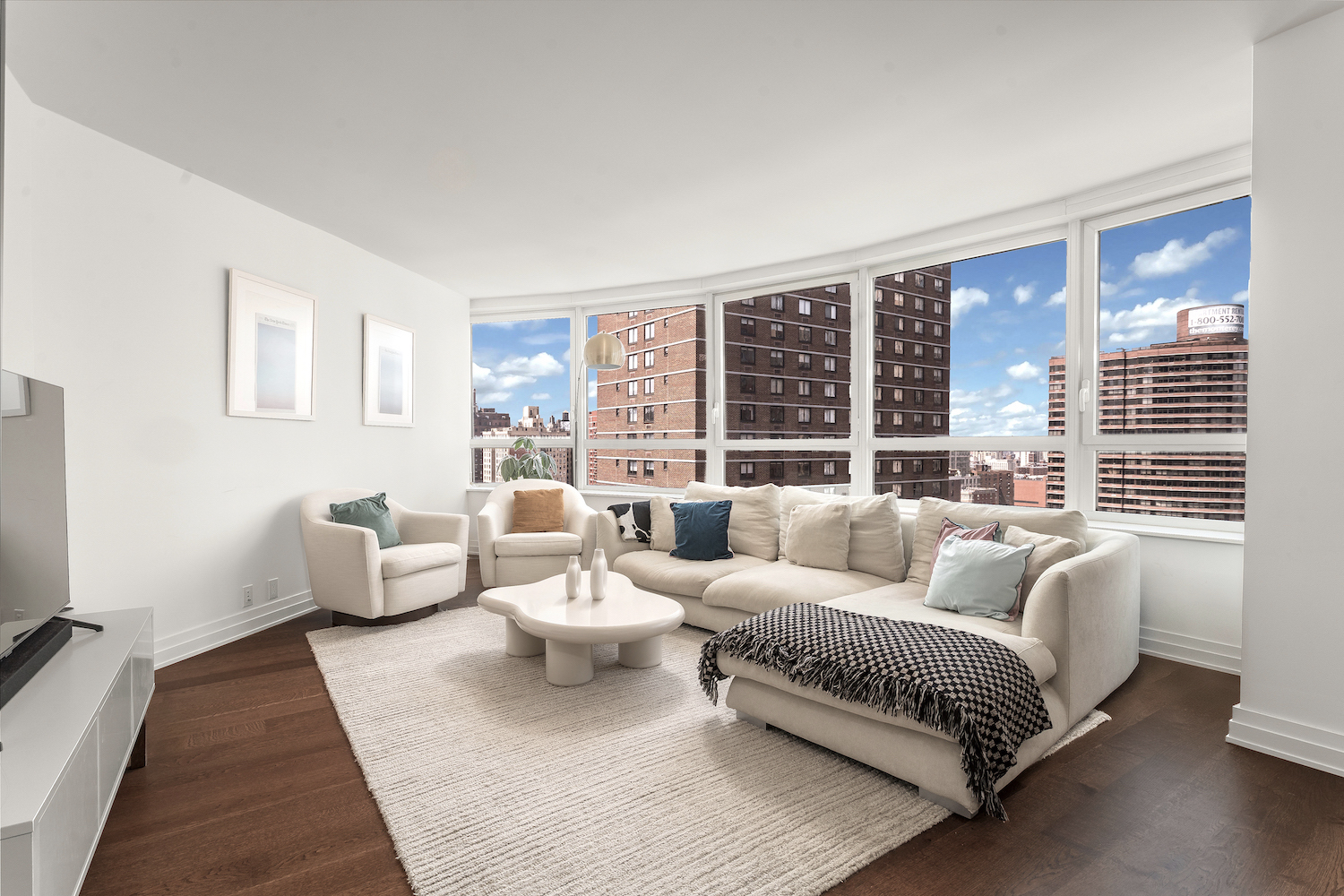 200 East 94th Street, Unit 2015 Manhattan, NY 10128 - Photo 1 of 16 a living room with furniture and large windows